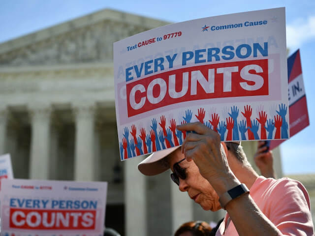 Image of a man holding a sign that says "Every person counts" outside of the U.S. Supreme Court.