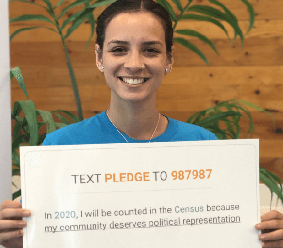 Andrea holds 2020 Census sign that reads Pledge to be Counted - CommunityConnect Labs