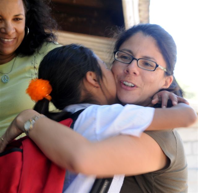 teacher hugging young student on Back to School Day